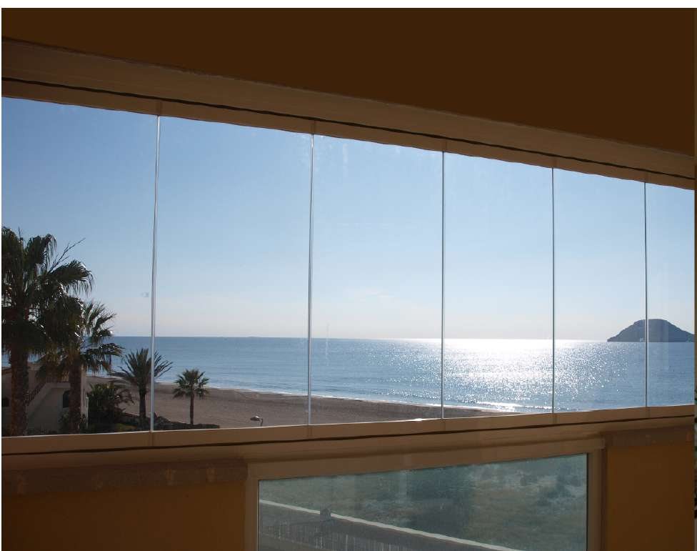 Vista del mar a través de una cortina de cristal sin perfiles verticales