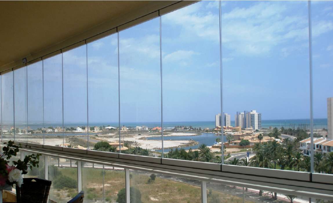 Terraza cerrada con cortina de cristal, con vistas a la costa
