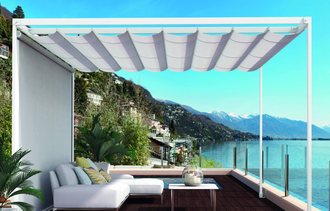 Toldo corredero con la lona en ondas sobre una terraza con vistas a un lago